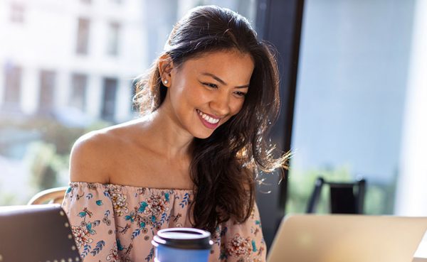 Beautiful Filipino woman using laptop at cafe