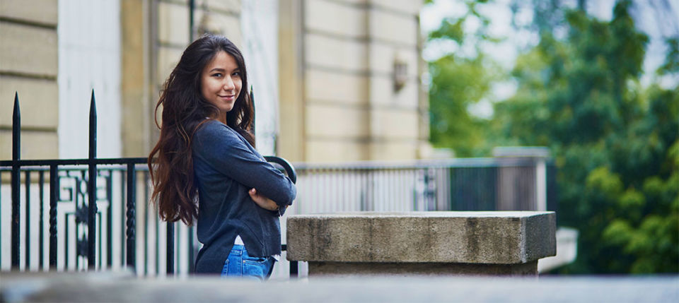 French cougar on a balcony smiling