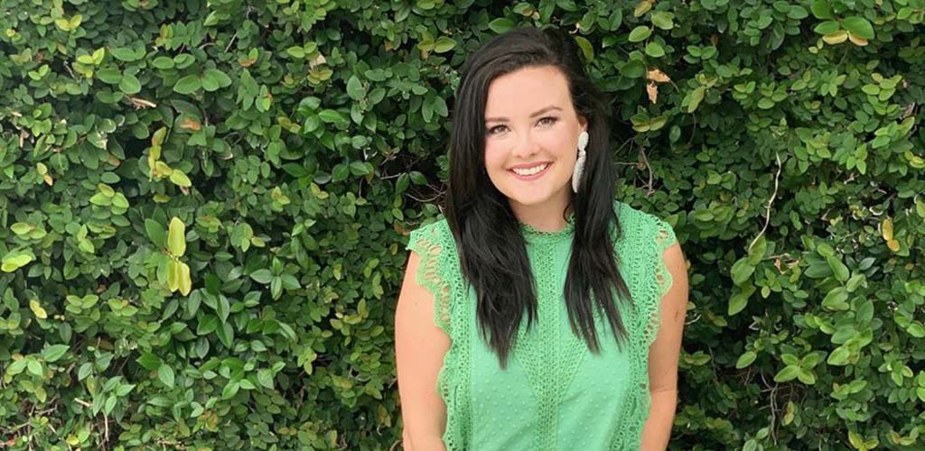 A beautiful woman at a plant wall in Four Chicks in the Park