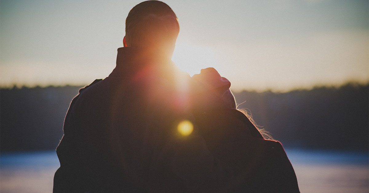 Man and woman looking at a sunset on a date