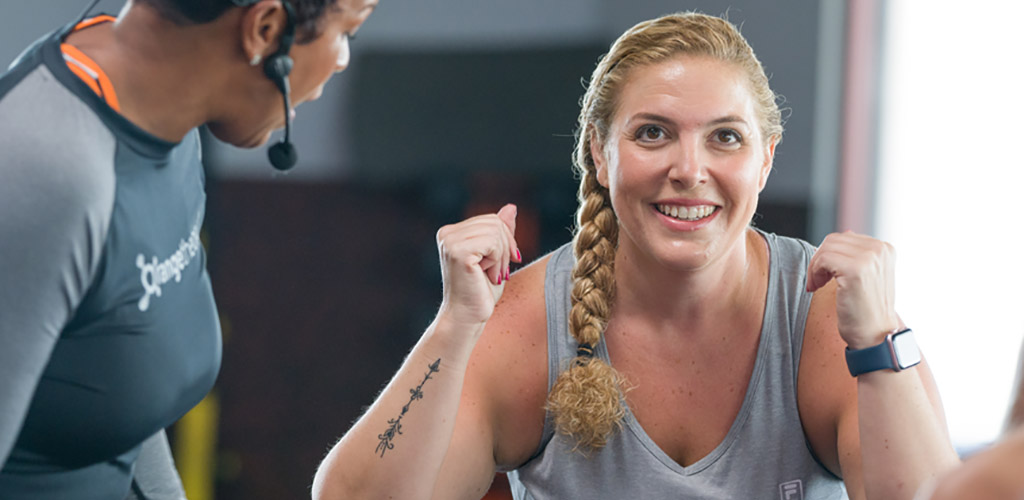 A curvy woman in a workout session at Orangetheory Fitness