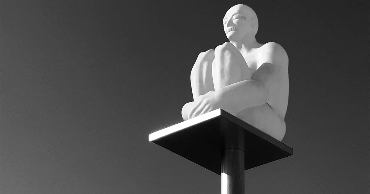 Person on a pedestal clutching legs