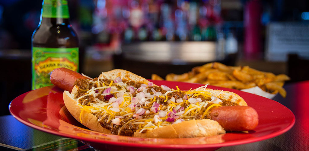 A hotdog with lots of toppings from Smitty's Garage Burgers and Beers 