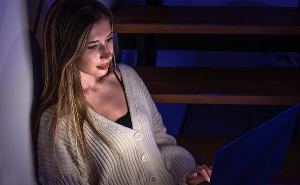 Person using laptop computer in modern home office exploring interactive online entertainment platform